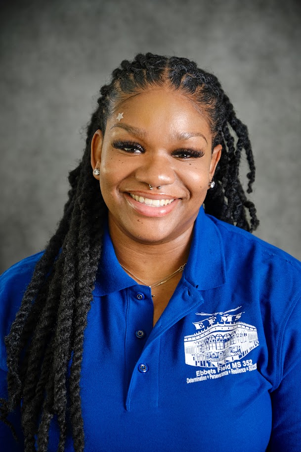 Student wearing blue school polo shirt smiling