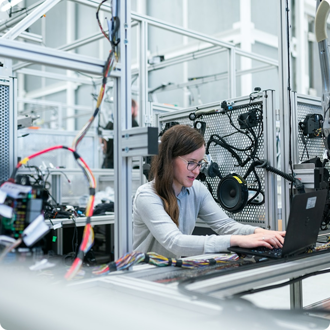 Person working on a laptop inside of an industrial office