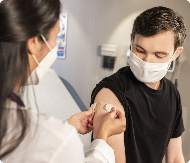 Health caretaker putting bandaid on patient after a vaccine.