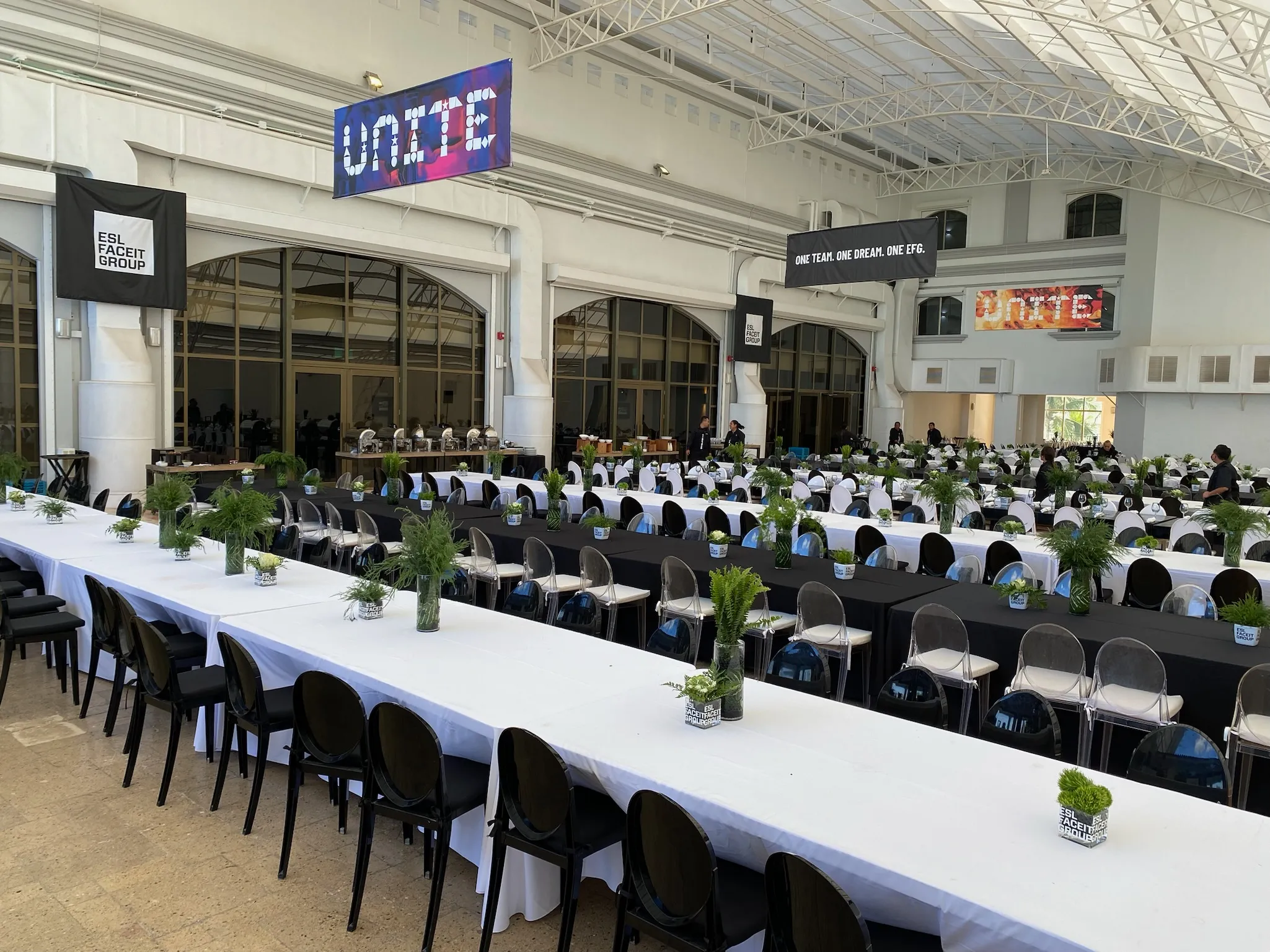 Long banquet tables arranged for lunch with coordinated black and white décor.