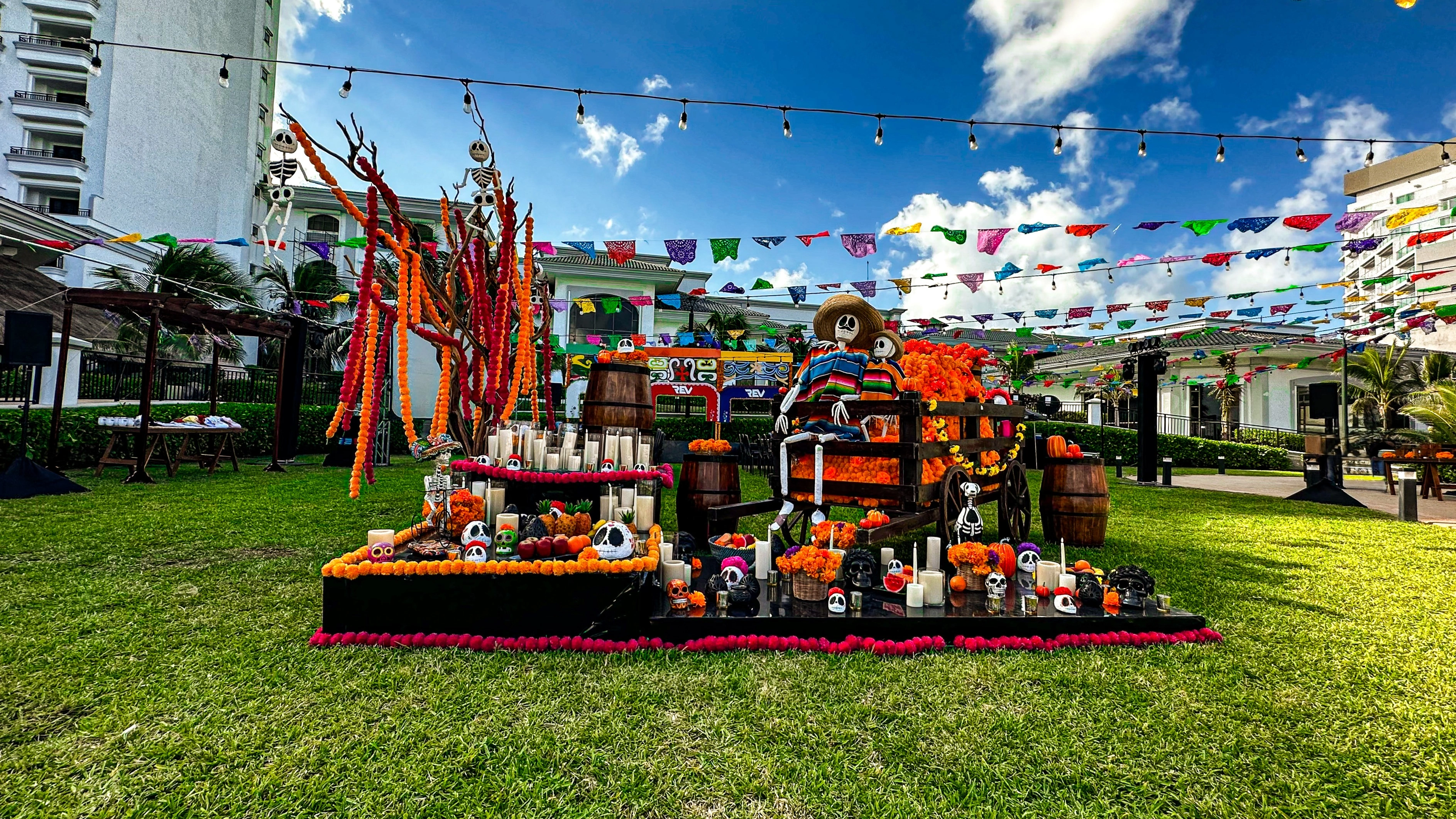 Completed Día de los Muertos celebration featuring a custom ofrenda, papel picado and themed scenic décor.