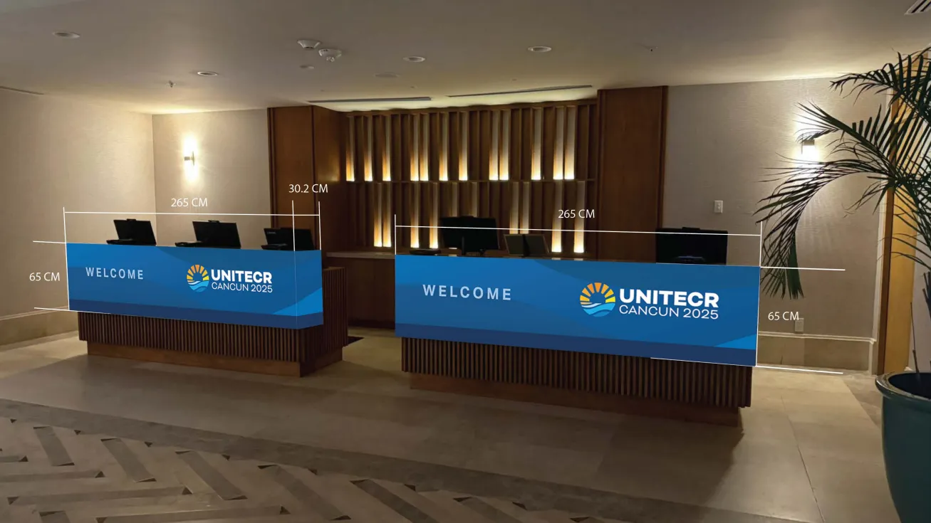 A photo edit of a hotel reception desk wrapped in custom branded graphics beneath wood paneling with dimensions.