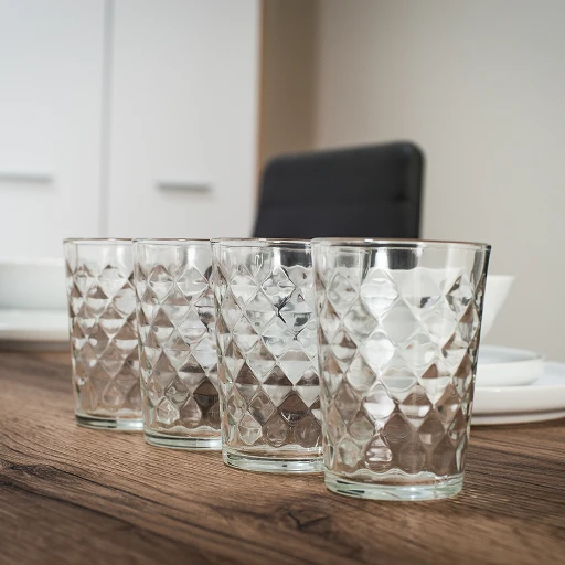 A group of glasses sitting on top of a wooden table.