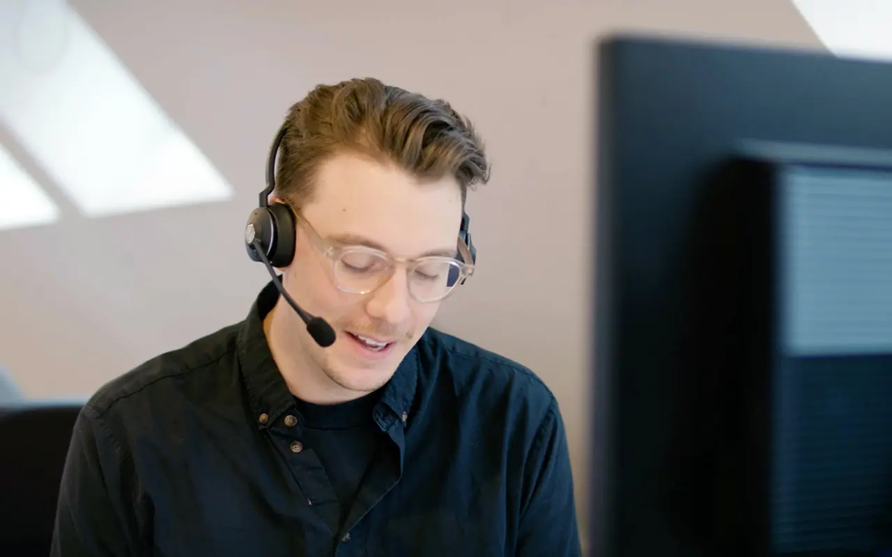 A man wearing a headset and using a computer.