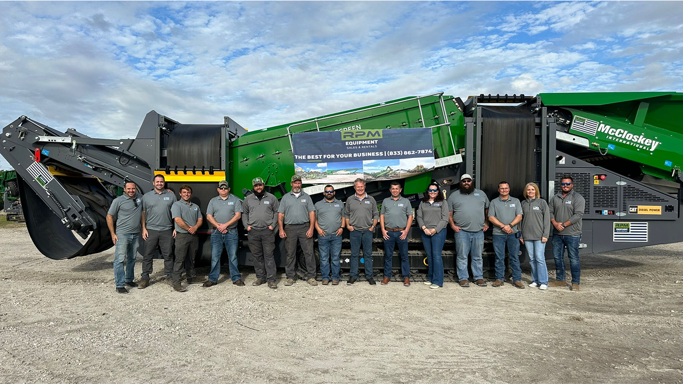 A group of men standing in front of a dump truck.