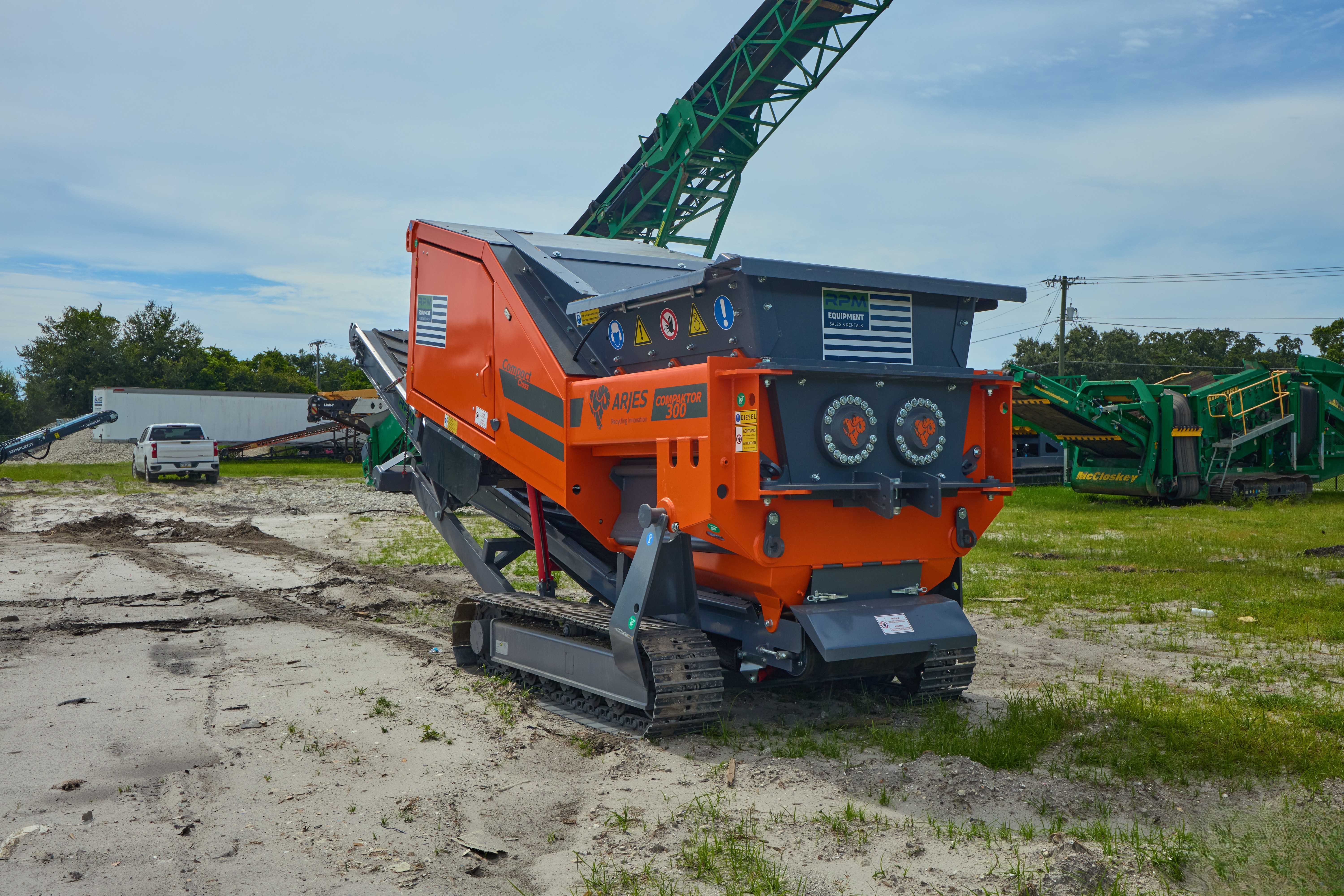 A large green machine sitting on top of a dirt field.