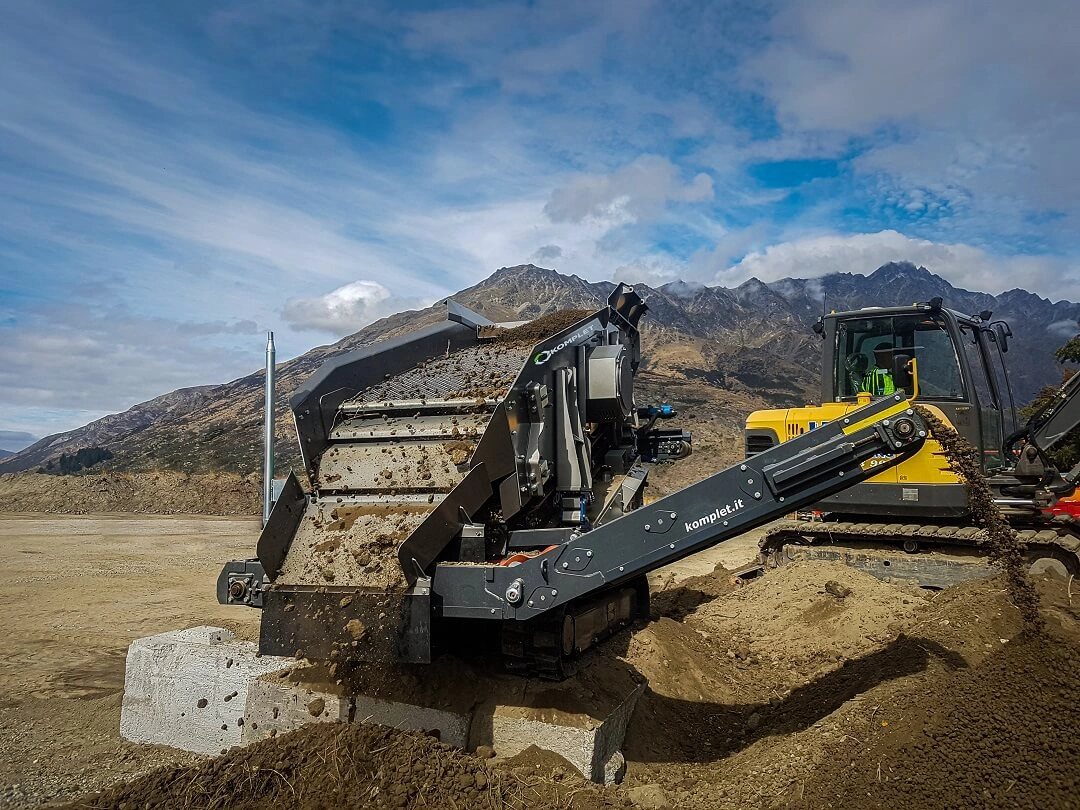 Komplet Kompatto 221 mobile screener processing material on a jobsite, designed for compact screening and recycling applications.