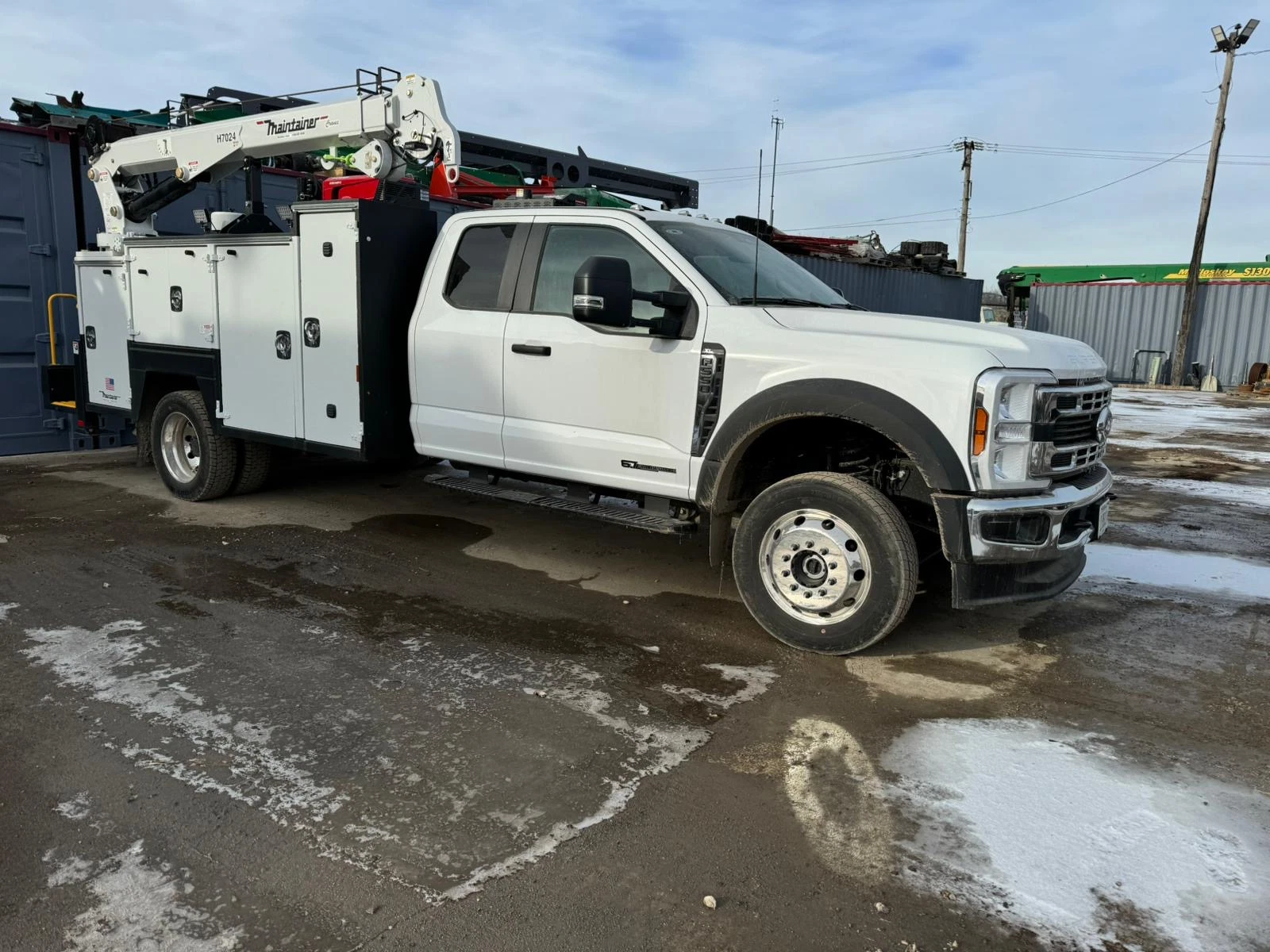 Heavy-duty service truck with onboard crane and tool storage, designed for field service and equipment maintenance.