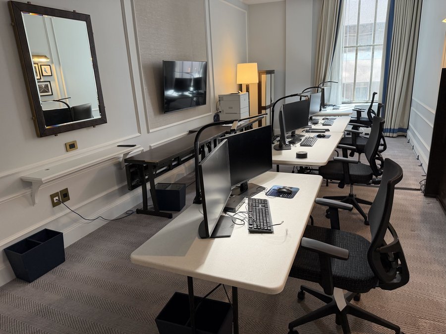 Trial office war room with dual-monitor workstations and printers