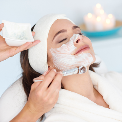 A woman getting a facial mask on her face.