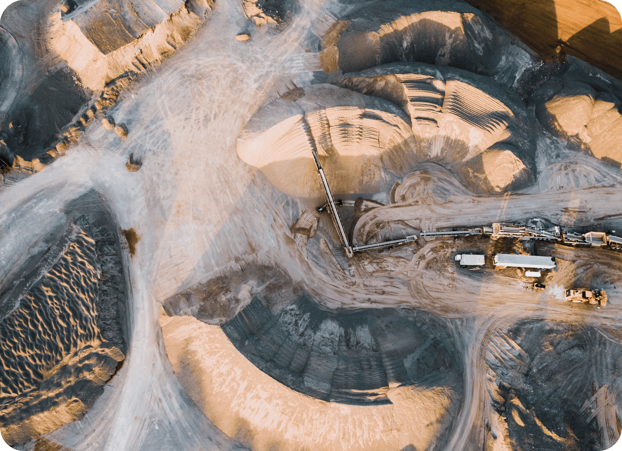 Mining site showing heavy machinery and workers extracting minerals