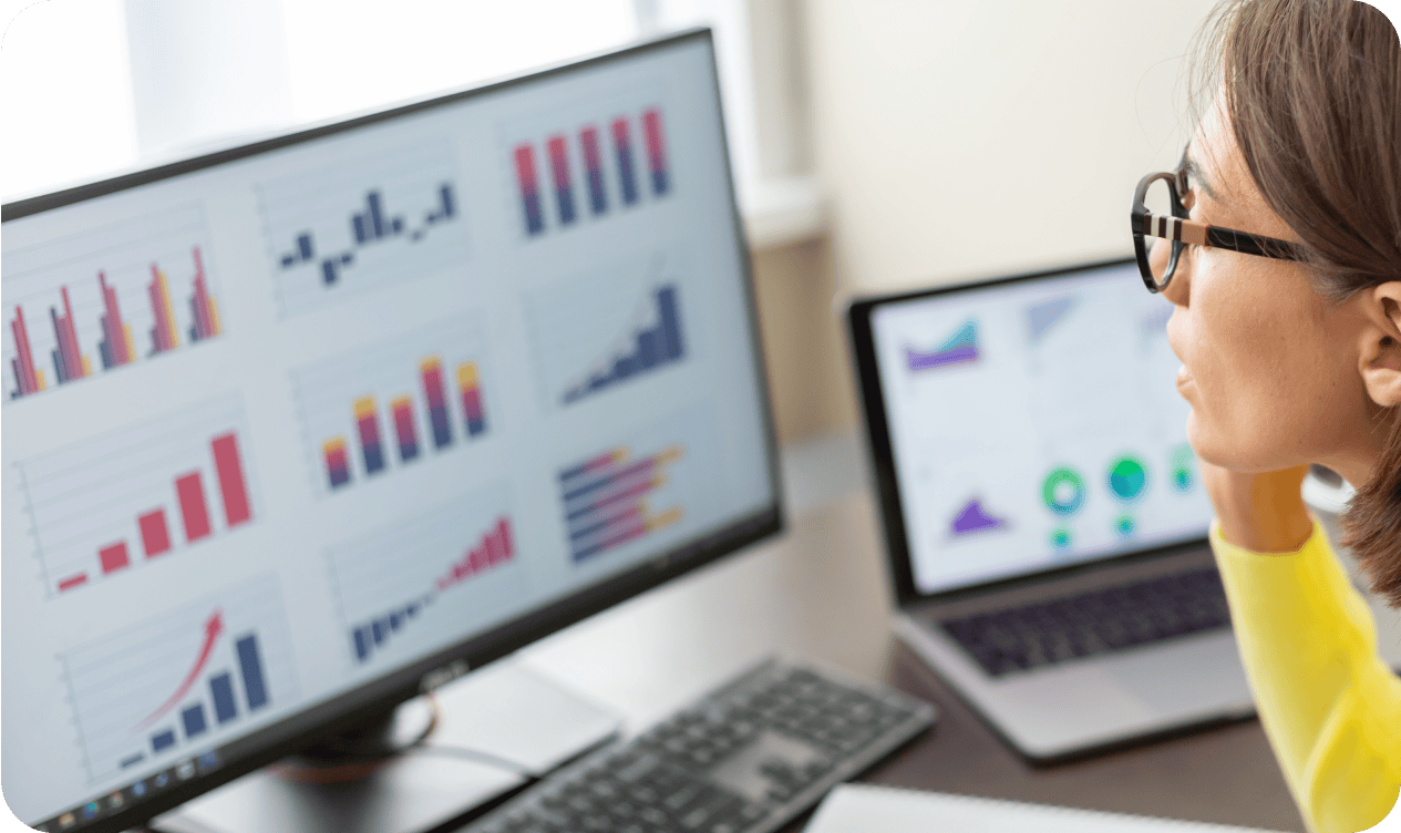 Person analyzing and reviewing graphs and data charts on a computer screen