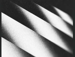 Close-up of diagonal shadows creating a striped pattern on a textured surface.