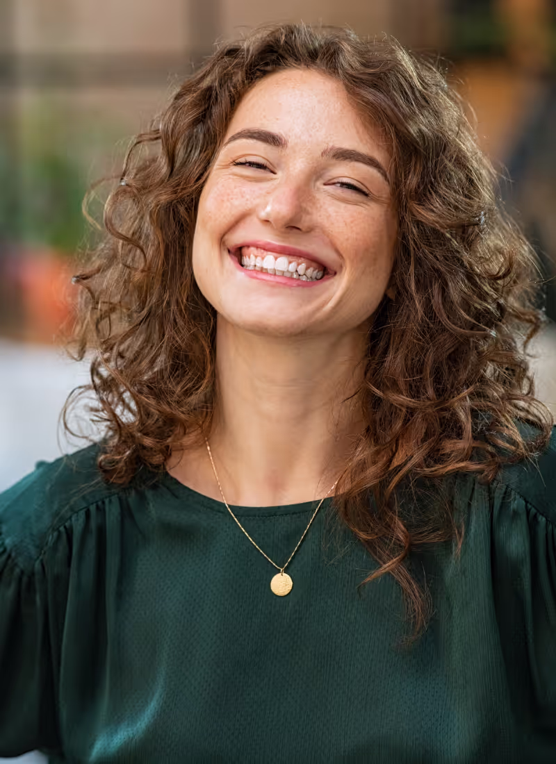 Woman in green shirt smiling.