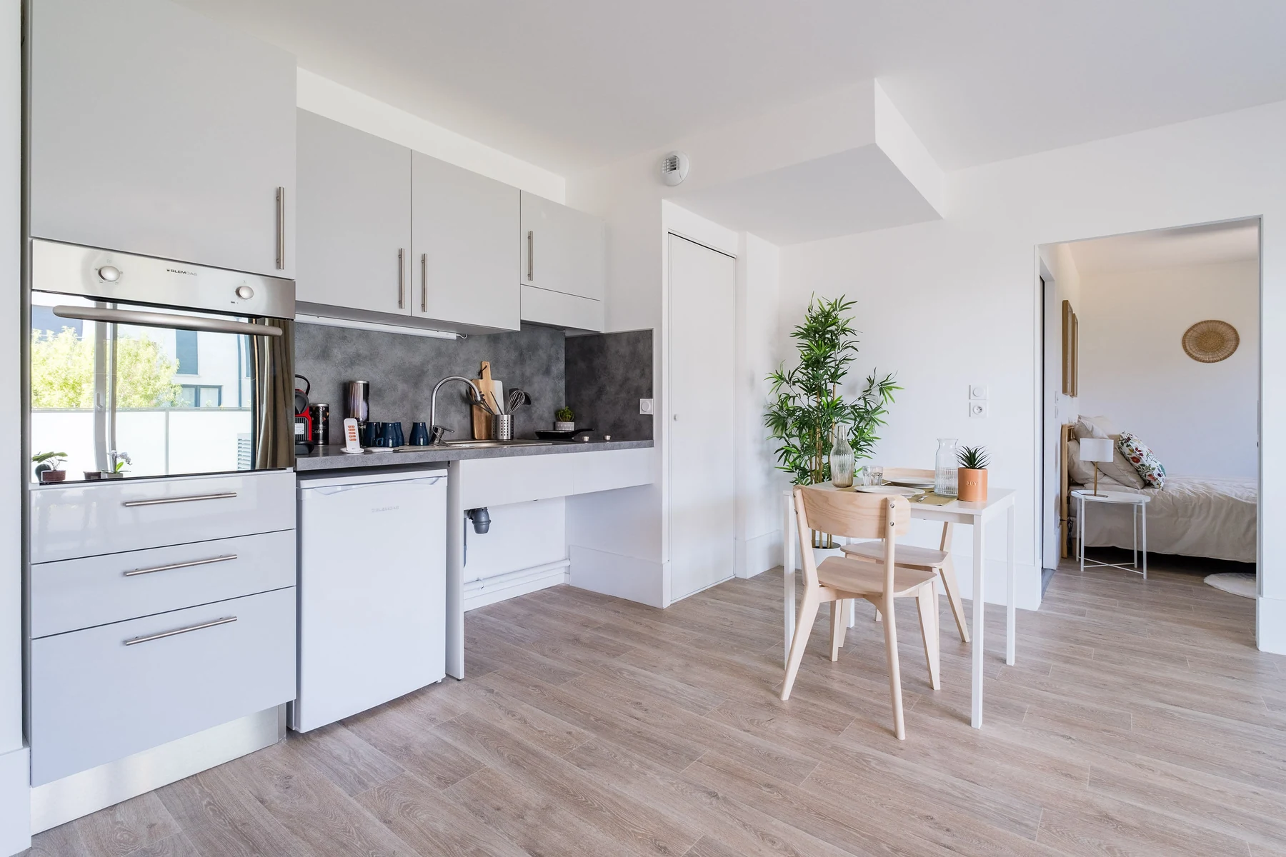 Cuisine équipée avec coin repas et vue sur la chambre – appartement adapté seniors et PMR Toulouse