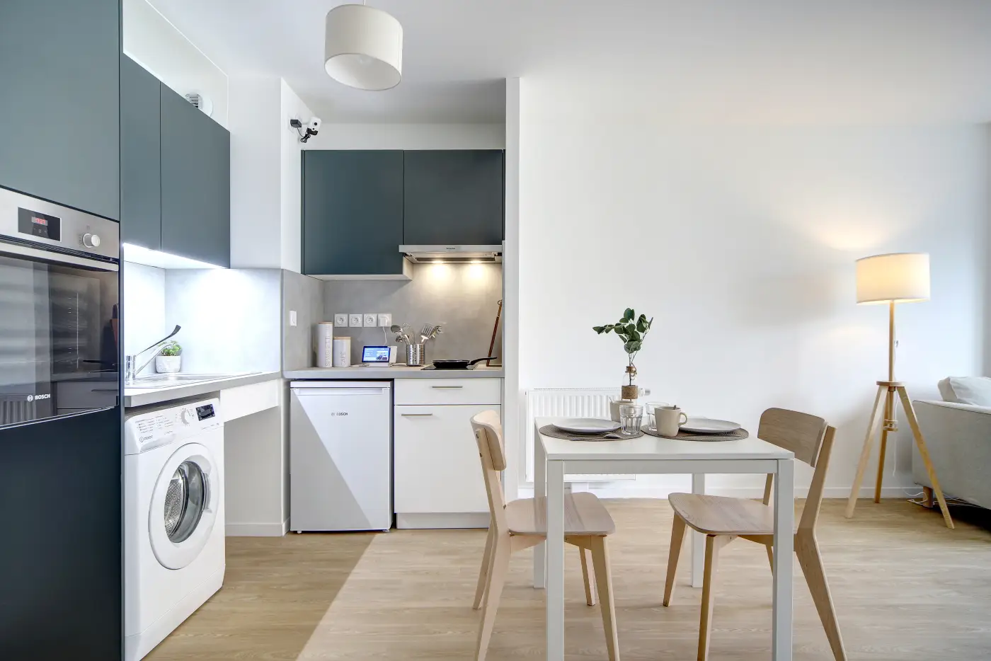 Cuisine d'un appartement Mobicap équipée d'un lave-linge et d'un réfrigérateur