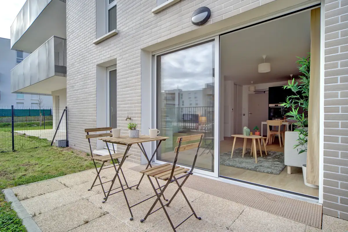 Terrasse privative d'un appartement Mobicap avec table et chaises de jardin