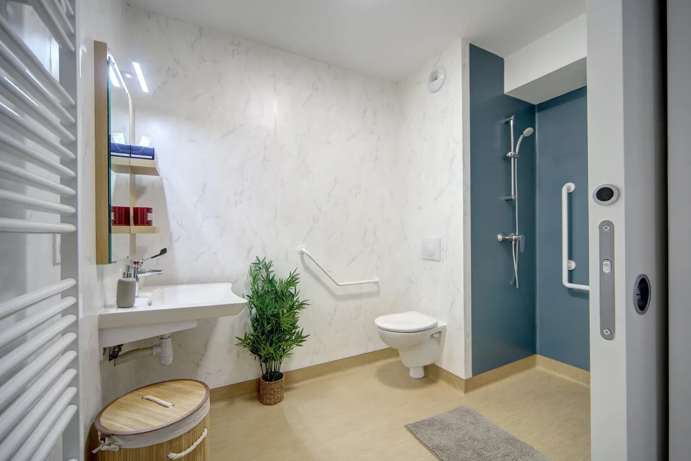 Douche sans seuil et barre d'appui dans la salle d'eau d'un appartement Mobicap