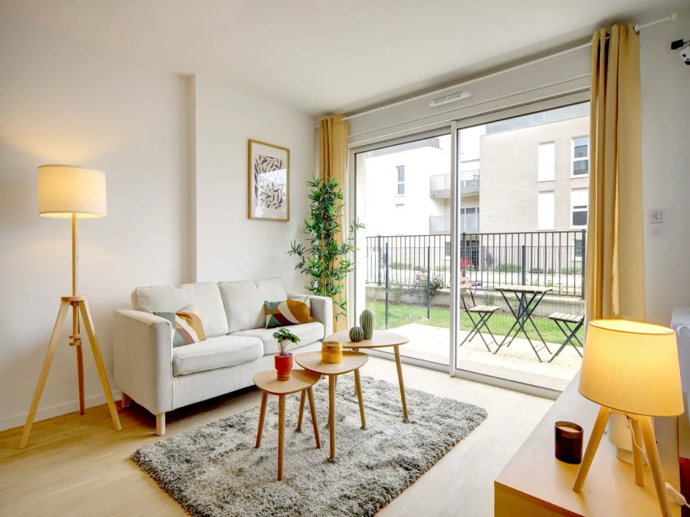 Séjour d'un appartement Mobicap avec canapé et baie vitrée sur la terrasse