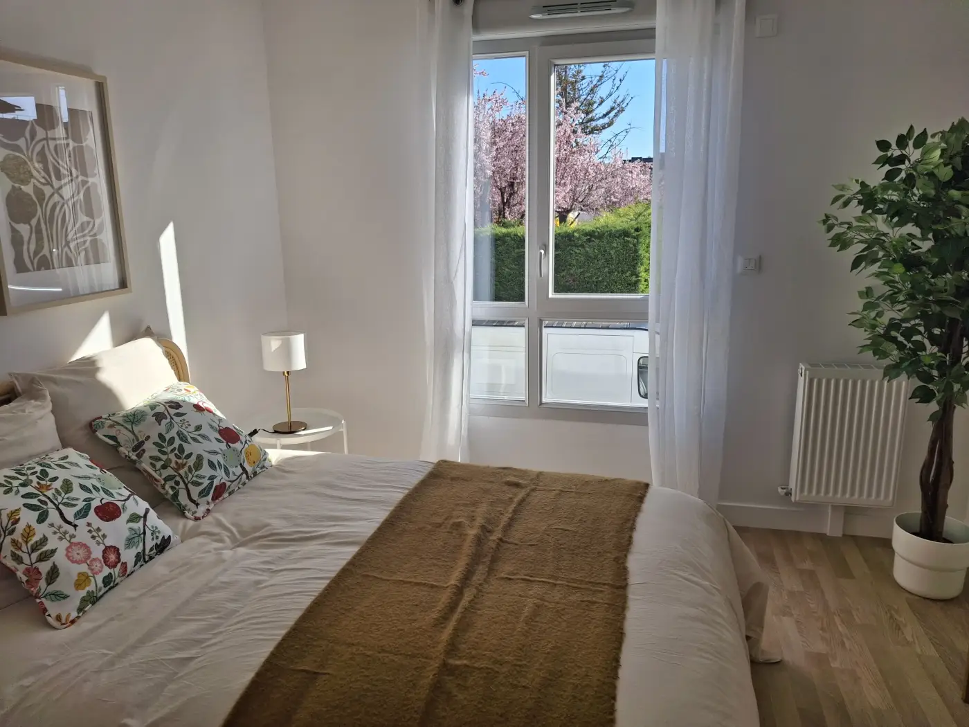 Chambre d'un appartement Mobicap à Dijon avec lit double et grande fenêtre