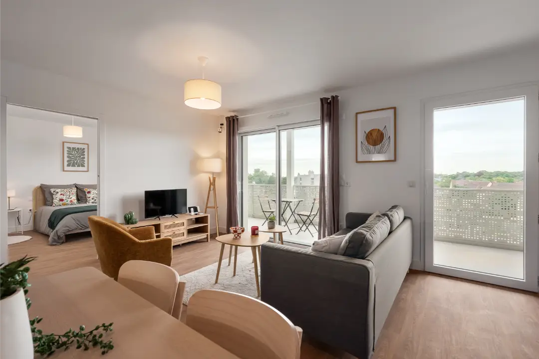 Salon avec canapé et accès au balcon, chambre au fond, appartement Mobicap au Havre