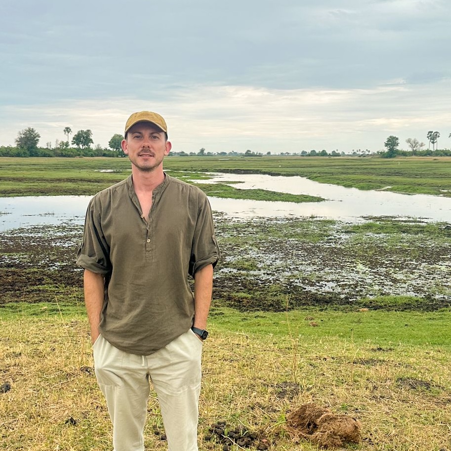 A man standing in the open plains of the Serengeti
