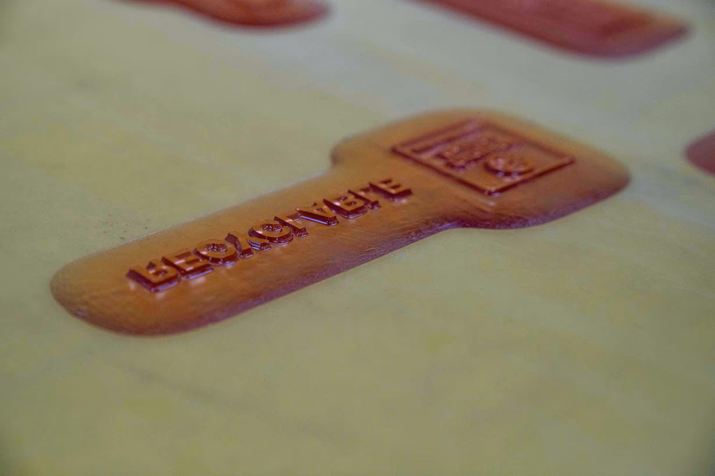 Close-up of a reddish wax seal with the word 'LEGACY' embossed on a yellow surface.
