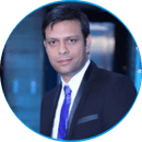 Professional headshot of Vishal Patel, a man wearing glasses and a dark business suit with tie, photographed against a neutral background
