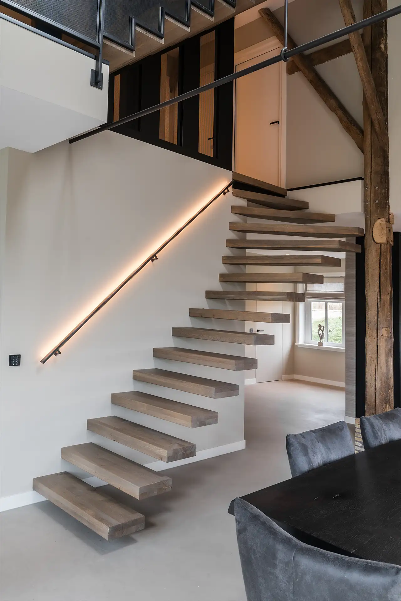 Moderne zwevende houten trap met ingebouwde verlichting aan de muur in een minimalistisch interieur.