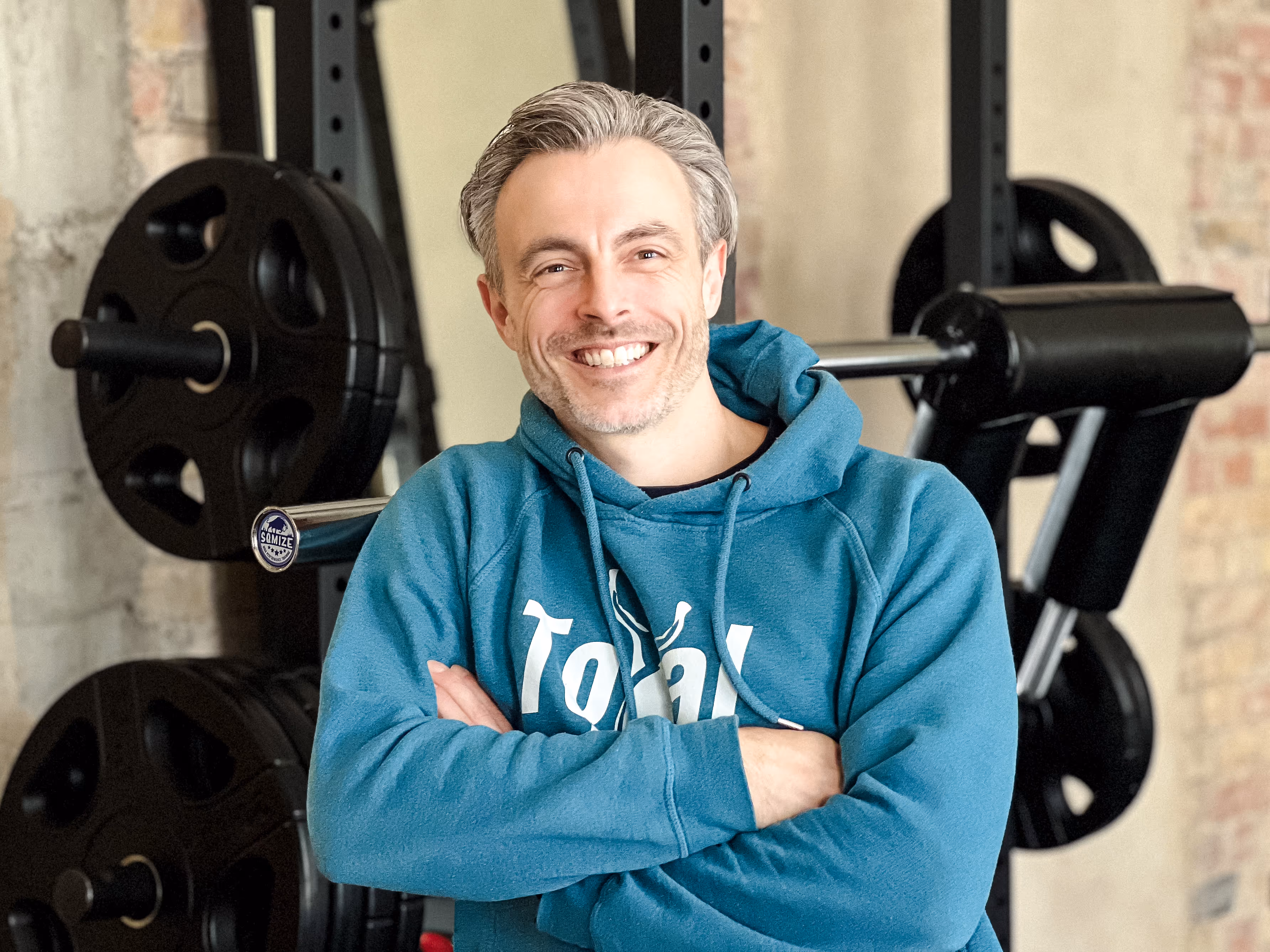 Porträt des Inhabers Mirco Theurer vor einem Geräteturm mit einem blauen Pullover