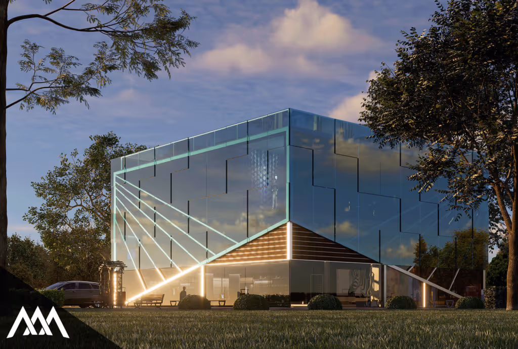 Modern glass building cube with illuminated diagonal lines at dusk surrounded by trees and grassy lawn.