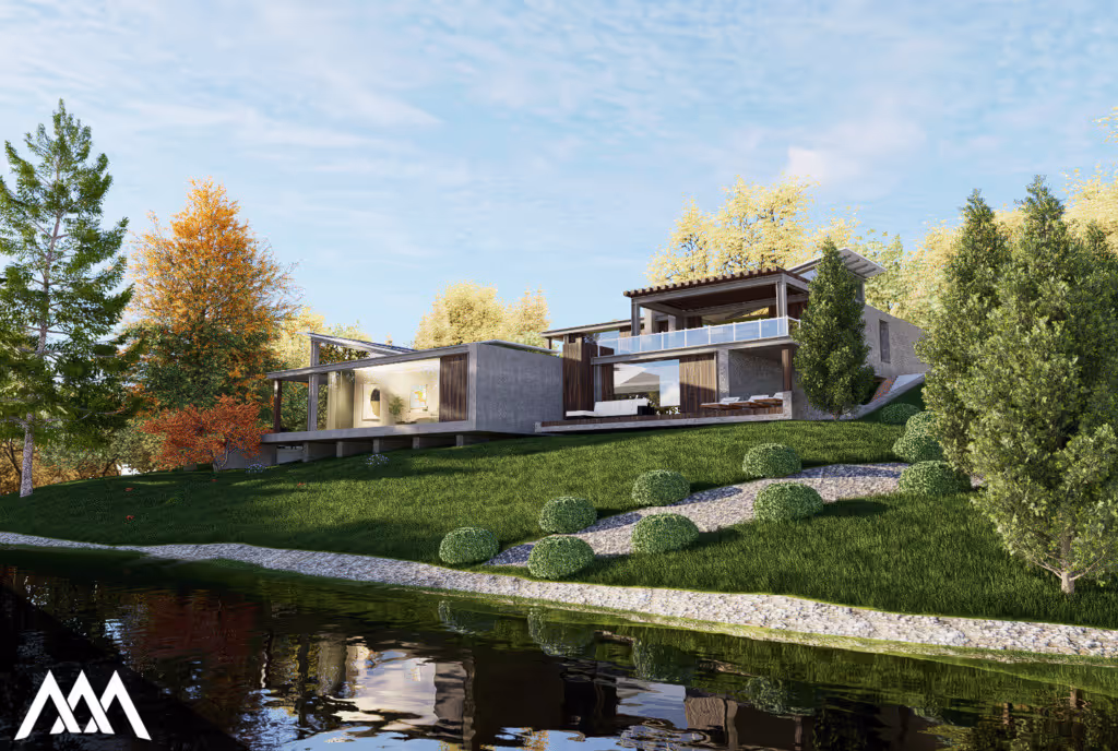 Modern house with large glass windows on a grassy hillside by a calm reflective pond, surrounded by green and autumn trees.