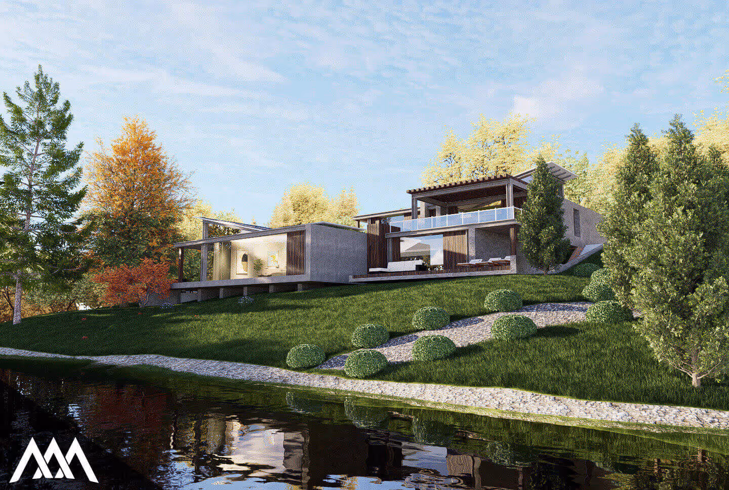 Modern house with large glass windows on a grassy hill beside a calm pond, surrounded by trees with autumn foliage.