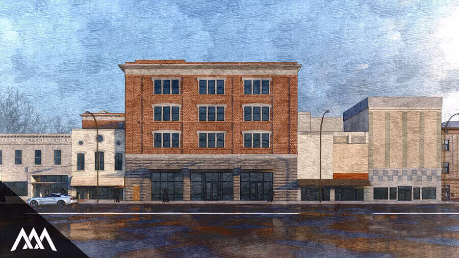 Street view of a five-story mixed brick and stone commercial building alongside adjacent structures under a blue sky with clouds.