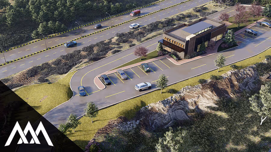 Aerial view of a modern coffee shop building with a parking lot surrounded by trees and rocky terrain.