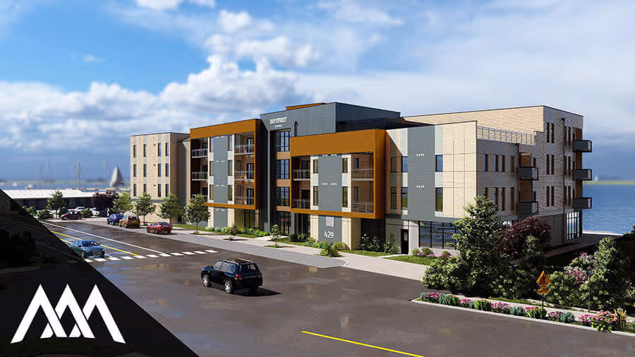 Modern three-story apartment building with a combination of beige and orange exterior panels, balconies, and large windows situated near a waterfront.
