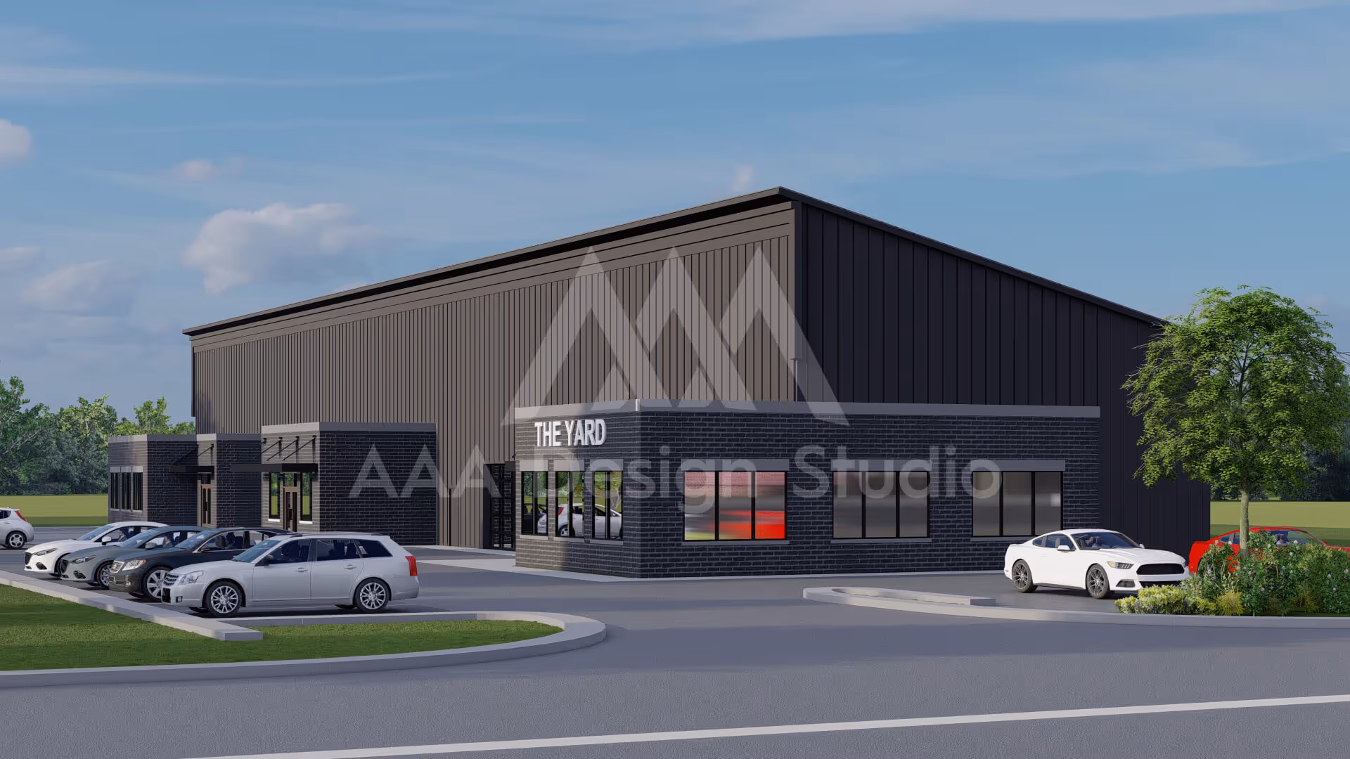 Modern black commercial building named The Yard with parked cars and landscaped greenery under a blue sky.