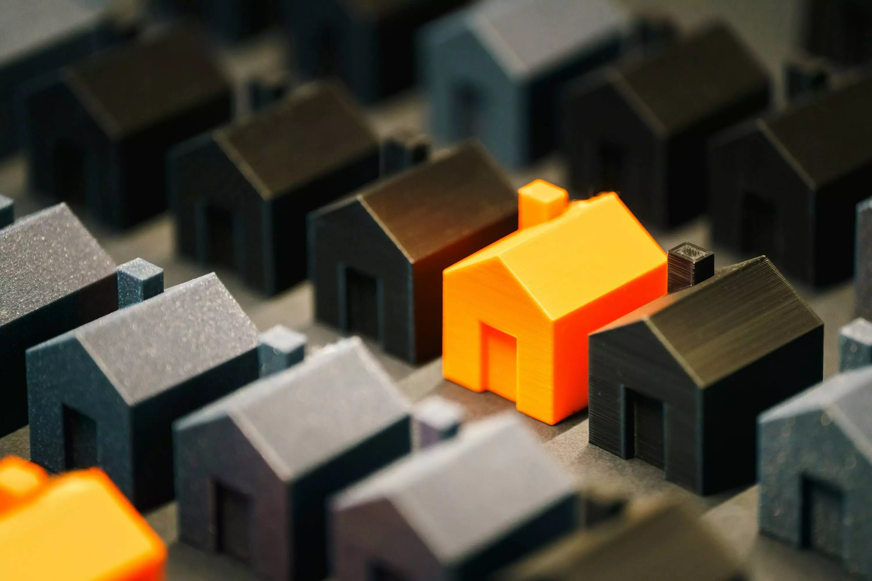 mini figurines de maisons grises noires et oranges alignées