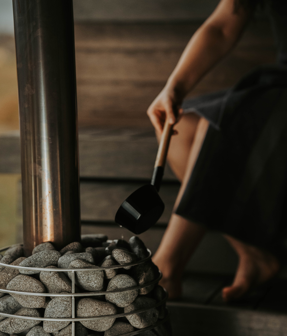 Femme assise près d’un mur en bois profitant d’un moment de détente au Refuge Chez La Tante — Megève.