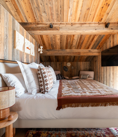 Salon chaleureux avec fauteuils en bois et lumière tamisée au Refuge Chez La Tante — Megève.