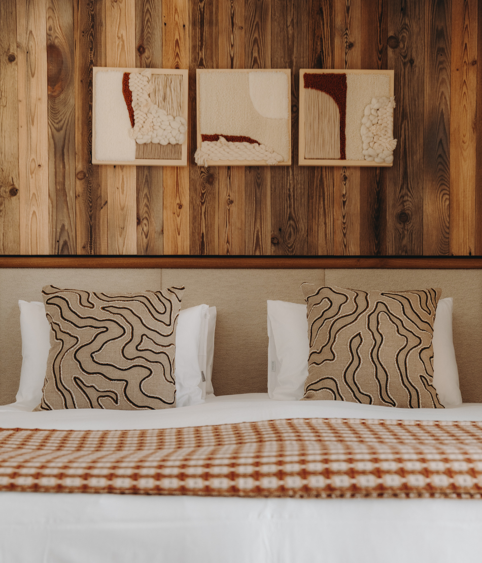 Warm living room with wooden armchairs and soft light at the Refuge Chez La Tante — Megève.