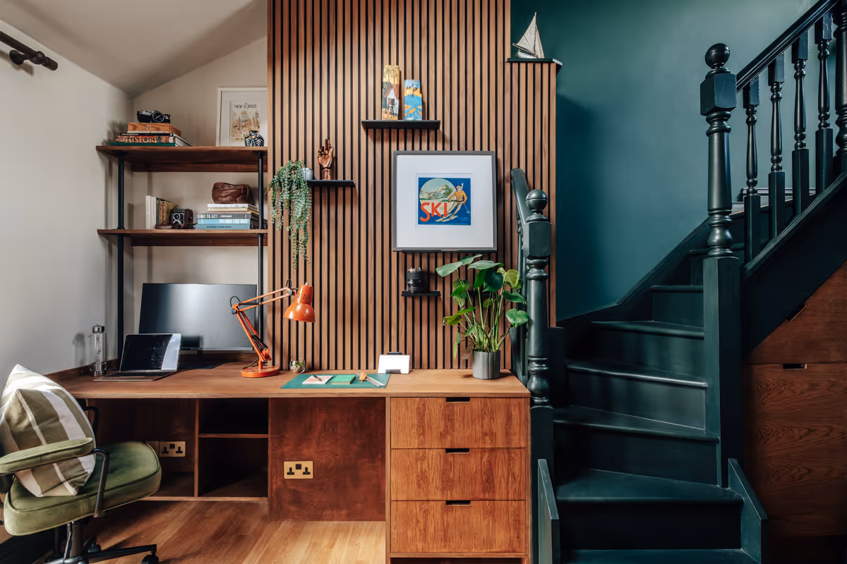 Preview of the Ross Road project with a pink wardrobe beside a white table holding potted plants, children's books, and rolled colouring sheets against floral wallpaper.