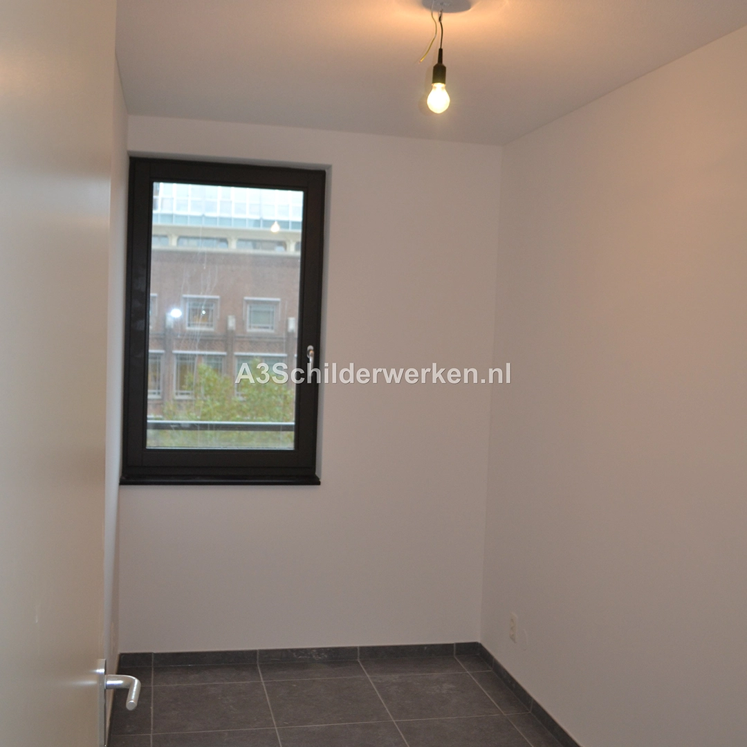 Strak afgewerkte kamer met glad gestucte en wit gesausde muren.