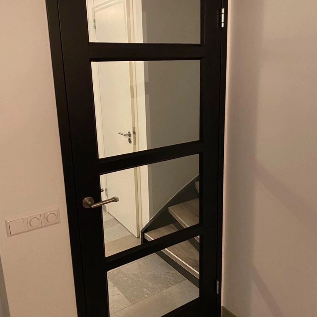 Een prachtig voorbeeld van hoe zwarte binnendeuren met glas zorgen voor een moderne en stijlvolle uitstraling. De combinatie met de lichte muren en strakke vloer versterkt het contrast en geeft het interieur een luxe, tijdloos karakter.