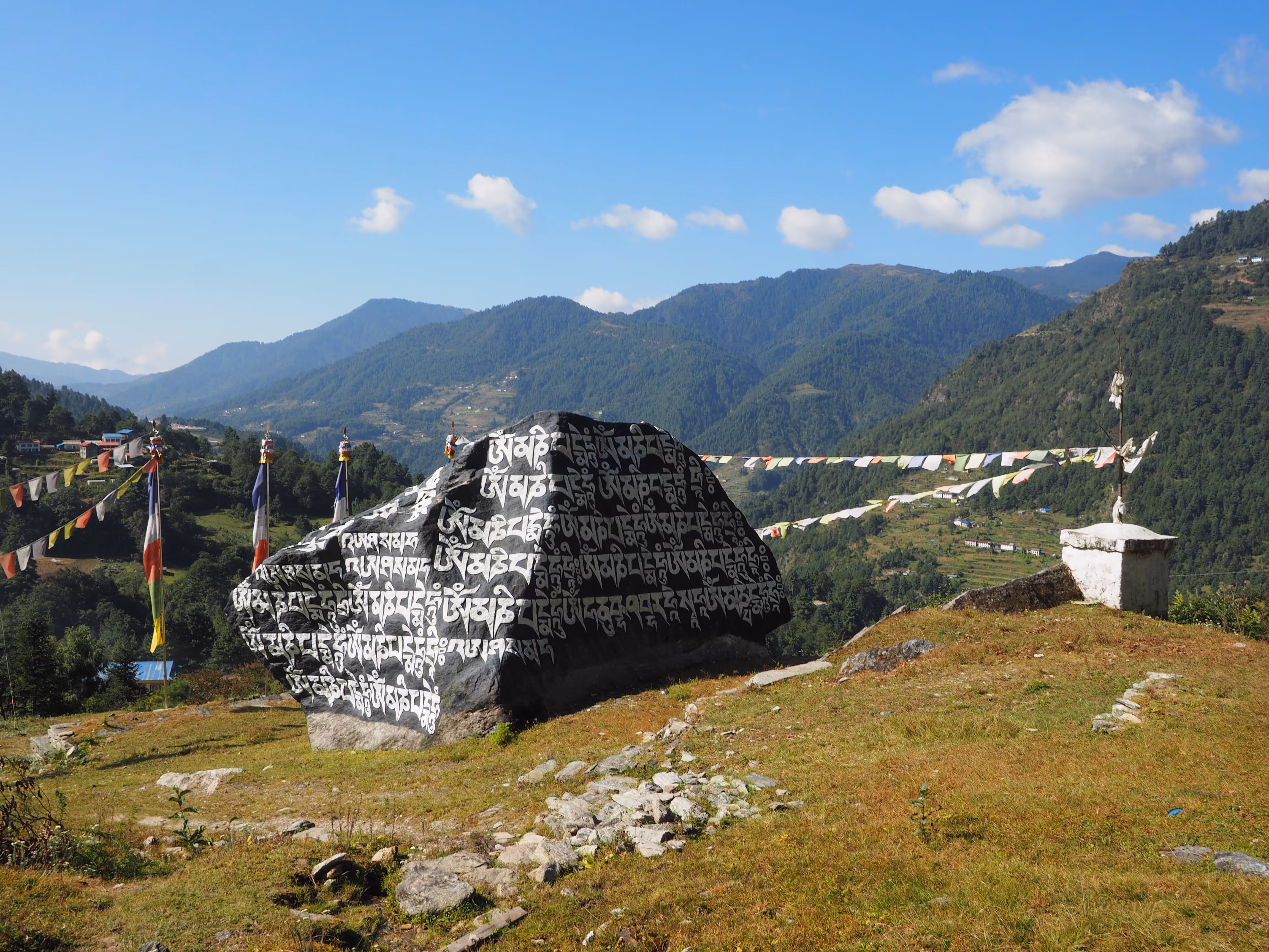 Village de montagne avec maisons en pierre et prairies.