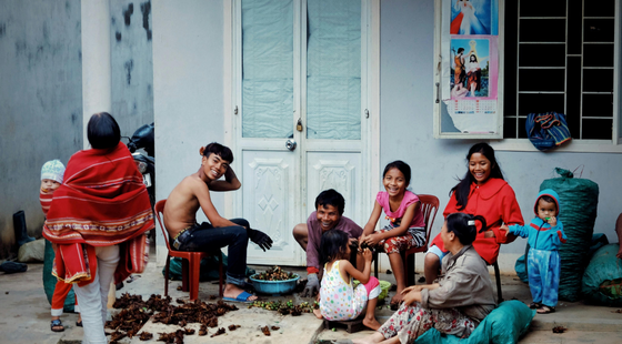 Groupe d’habitants assis devant une maison au Népal.