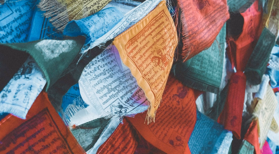 Drapeaux de prières tibétains vu de près colorés flottant au vent.