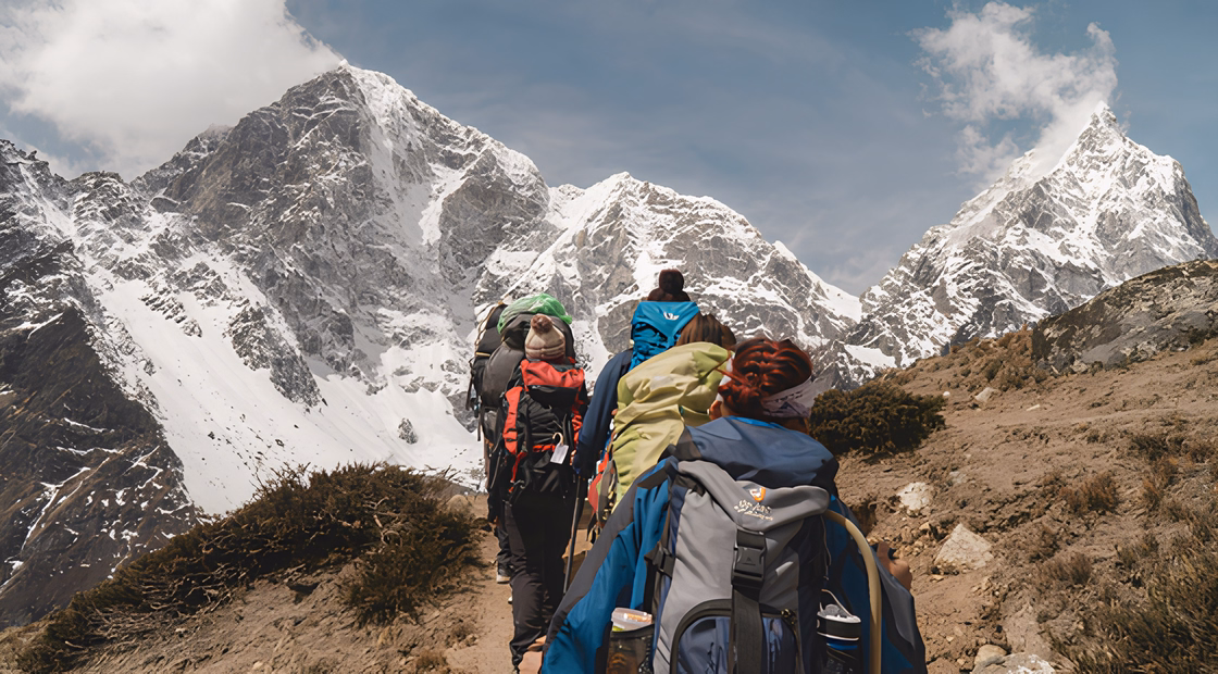 Trekkeurs progressant sur un sentier himalayen enneigé.