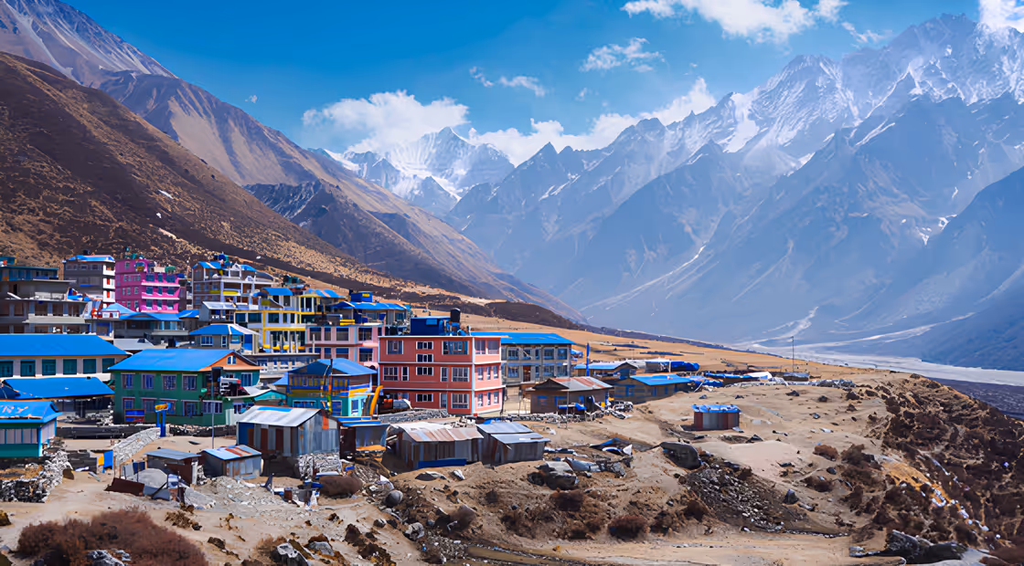Village de haute altitude au pied des montagnes enneigées.