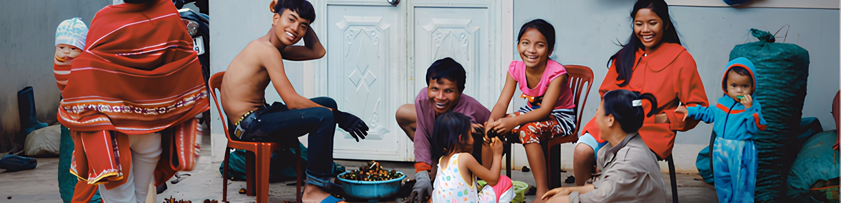 Groupe de locaux assis en extérieur autour d’une table dans leur village.
